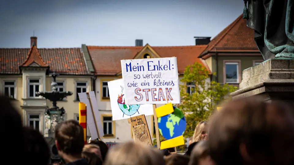 Menschenmenge von Aktivisten in Erlangen, Deutschland, die Plakate bei einem Protest gegen den Klimawandel halten.