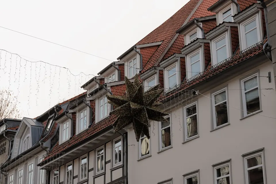 Schöne Weihnachtsdekorationen schmücken klassische deutsche Stadthäuser in Göttingen während der Winterzeit.