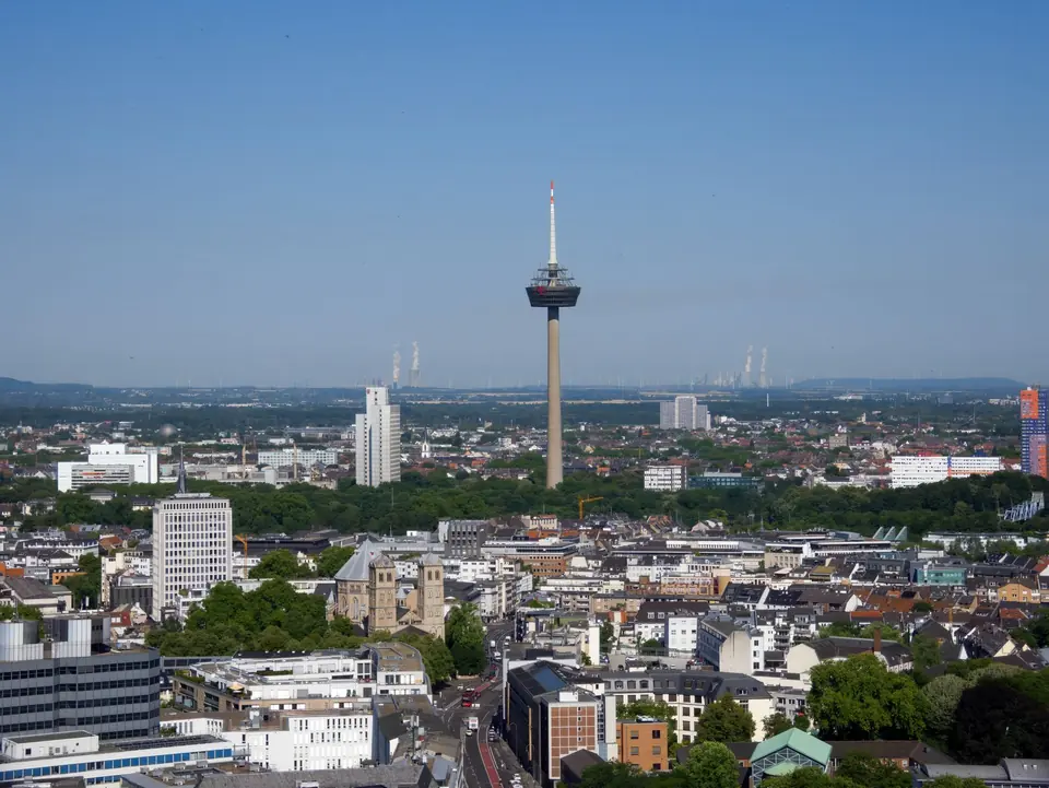 Atemberaubende Luftaufnahme von Köln mit dem ikonischen Fernsehturm Colonius unter einem klaren blauen Himmel.