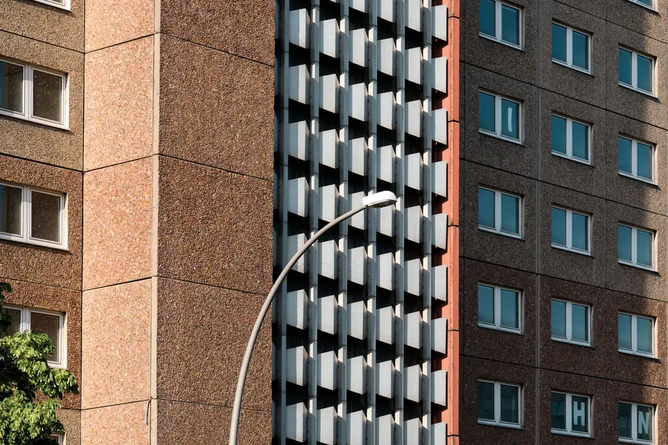 Sonnendurchflutete Fassade eines Plattenbaugebäudes in Berlin, die den urbanen Architekturstil präsentiert.