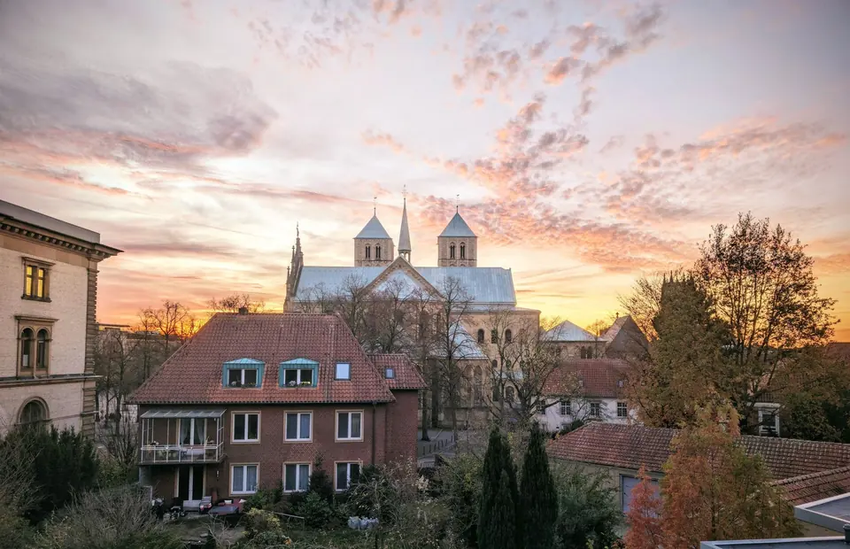 Malerische Ansicht des historischen Münsteraner Doms und der umliegenden Stadtlandschaft bei Sonnenuntergang.
