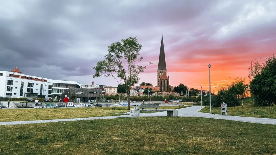 Abendansicht von Rostock, Deutschland, die historische Architektur unter einem lebhaften Himmel hervorhebt.