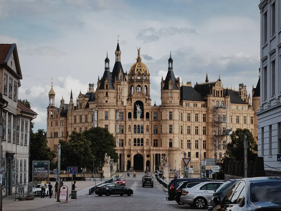 Atemberaubender Blick auf das Schweriner Schloss, ein ikonisches Wahrzeichen in Schwerin, Deutschland, umgeben von urbaner Architektur.